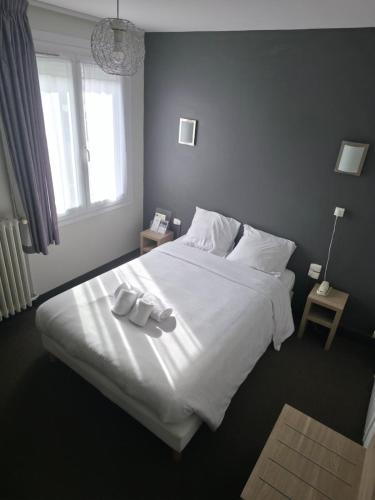 a bedroom with a large bed with two white dishes on it at The Originals City, Hôtel Le Savoy, Caen in Caen
