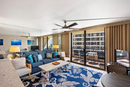 a living room with a blue couch and a balcony at SUGAR BEACH RESORT, #409 in Kihei