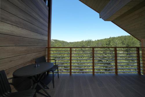 a room with a table and chairs on a balcony at Panorama Mountain Tara in Kaludjerske Bare