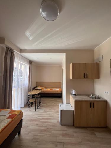 a room with a kitchen and a bedroom with a bed at Pokoje Blisko Morza SUNSET in Ustka