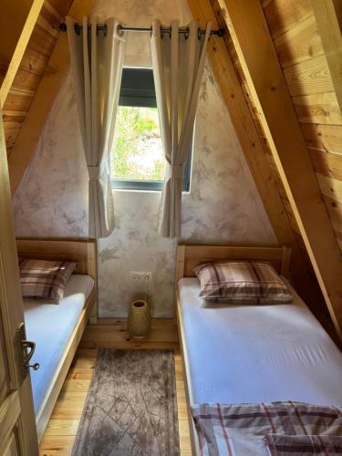 two beds in a small room with a window at Frogland in Žabljak