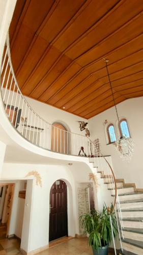 a large room with a wooden ceiling and stairs at Hotel Garni Forsthaus Ruhpolding incl Chiemgau Karte in Ruhpolding