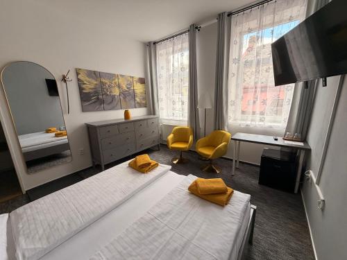 a bedroom with two beds and a desk and a mirror at Hotel Praděd Rýmařov in Rýmařov