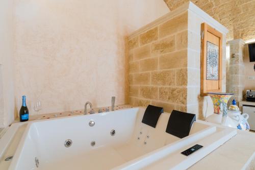 a large white bath tub in a bathroom at Corte Donato Grasso Relax - Salento Selection in Alessano