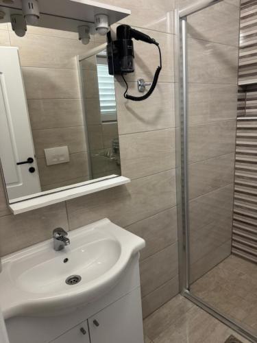 a bathroom with a shower and a sink and a mirror at House 100m from the beach with free parking in Baška Voda