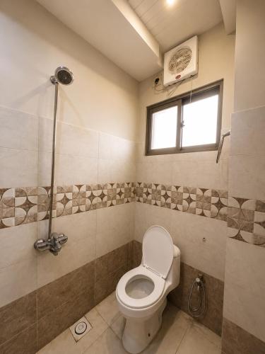 a bathroom with a toilet and a window at Family-Friendly Luxury Apartment Home Away From Home in Islamabad