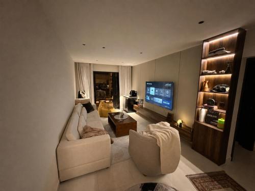 a living room with a couch and a television at Copper Living in Muscat