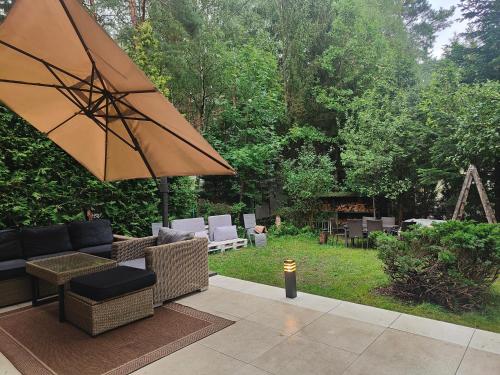 a patio with a couch and an umbrella at Kamińsko 544 in Kamińsko