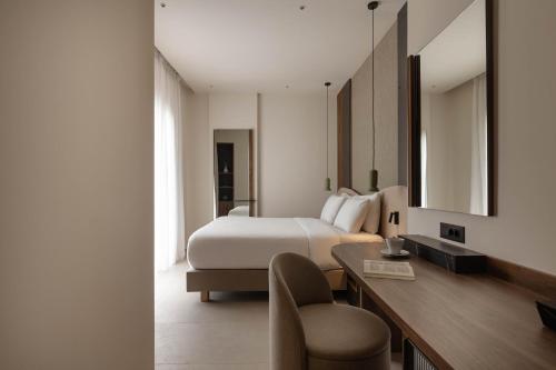 a hotel room with a bed and a desk at Nesean Plaza Hotel in Heraklio