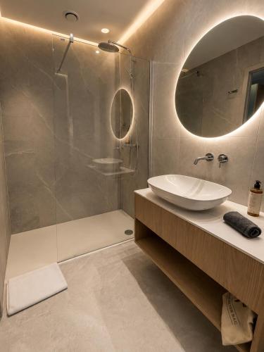 a bathroom with a sink and a shower with a mirror at Tower Hotel Wrocław in Wrocław
