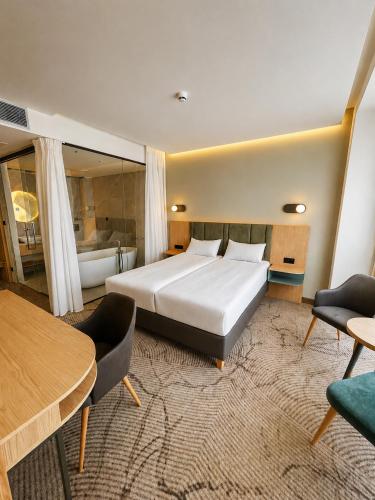 a hotel room with a bed and a table and chairs at Tower Hotel Wrocław in Wrocław