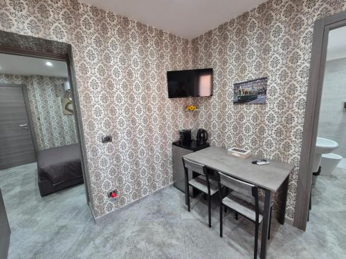 a dining room with a table and a television on a wall at B&B Monviso in Casavecchie