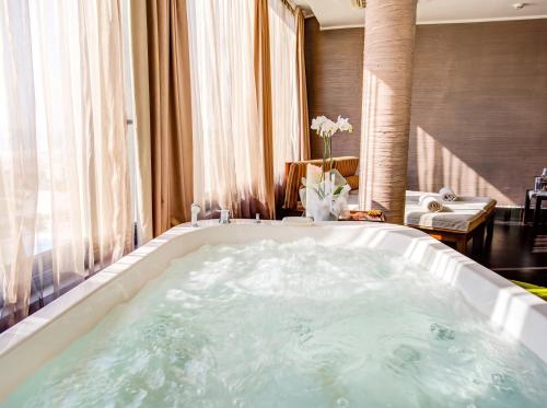 a large bath tub in a room with a living room at Hotel Premier & Suites - Premier Resort in Milano Marittima