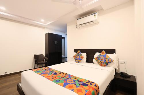 a bedroom with a large bed with a colorful blanket at FabHotel Excella Vizag in Visakhapatnam