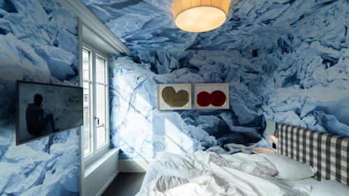 a bedroom with a blue wall with hearts on it at Boutique & Art Hotel Helvetia in Zurich
