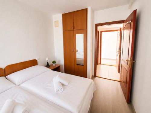 a bedroom with a white bed and a window at PSZ Hotel Beach Földvár in Balatonföldvár