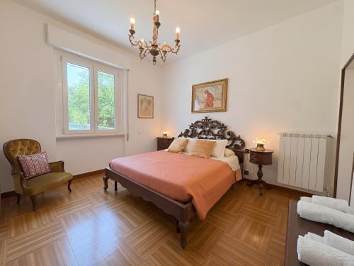 a bedroom with a bed and a chair and a chandelier at La Casa dell'Anello - Relax & View - ItalyWeGo in Narni