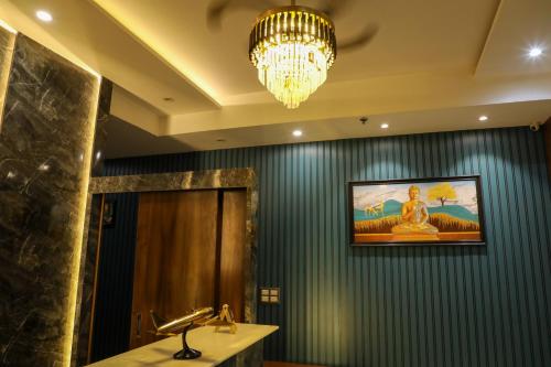 a bathroom with a chandelier and a sink and a mirror at Hotel Helios in Zirakpur