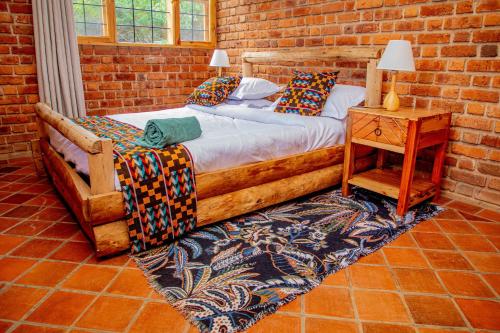 a bedroom with a bed and a brick wall at Tranquil Hillhouse in Nkoanrua