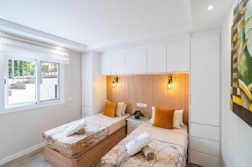 a small room with two beds and a window at Cubo's Violeta Rural House in Coín