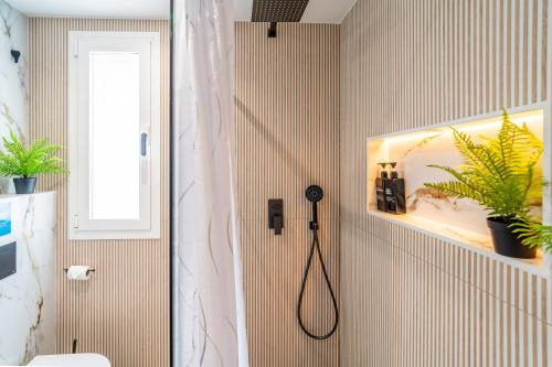 a bathroom with a shower with a black shower head at Cubo's Violeta Rural House in Coín