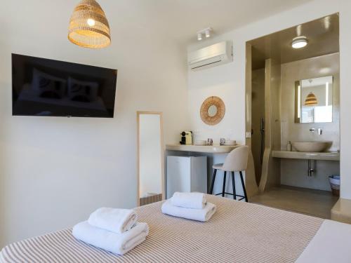a bedroom with a bed with two towels on it at Dival Properties Mykonos 1 & 2 in Megali Ammos
