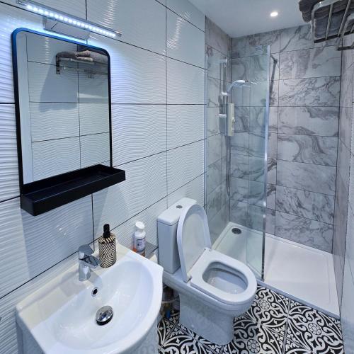 a bathroom with a sink and a toilet and a shower at Chata in Stornoway