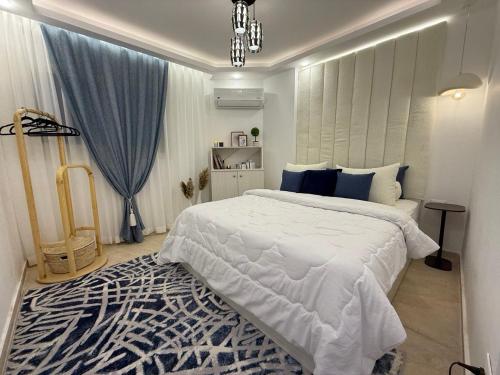 a bedroom with a large white bed and a rug at Smart Home near beach and pool in Sharm El Sheikh