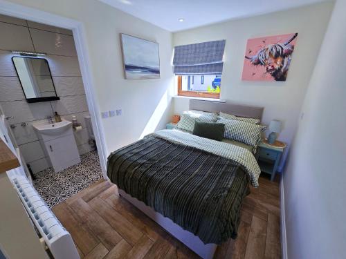 a small bedroom with a bed and a sink at Chata in Stornoway