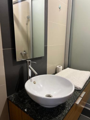 a bathroom with a white sink and a mirror at Hanik Homes in Kampala