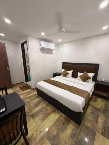 a bedroom with a large bed and a desk at Hotel Vasundhara Villa - Greater Kailash in New Delhi