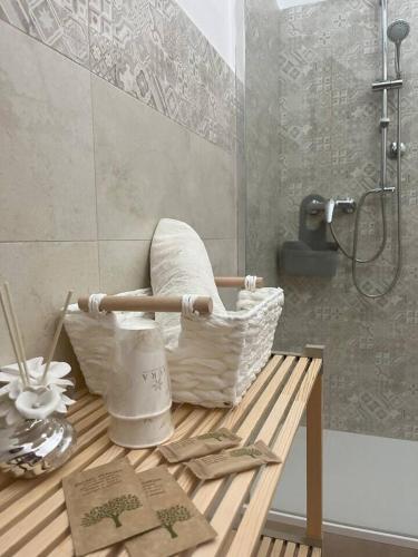 a bathroom with a table with a basket and a shower at Villa Maria B&B in Marano Principato