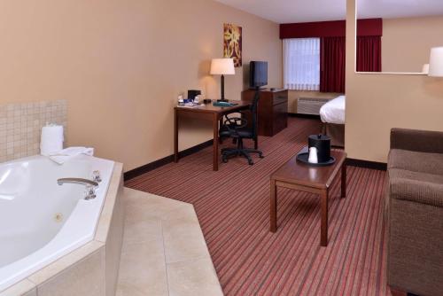 Habitación de hotel con baño con lavabo y escritorio. en Best Western Woodland Inn en Woodland