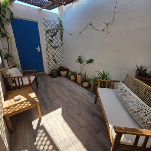 a living room with a couch and tables and potted plants at כרמונ'ס פטיו - Carmona's Patio in Eilat