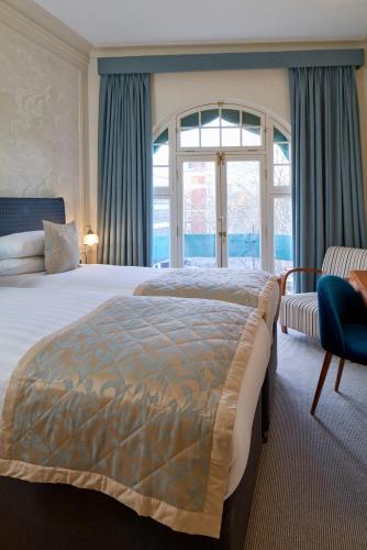 ein Schlafzimmer mit einem großen Bett und einem Fenster in der Unterkunft Sloane Square Hotel in London