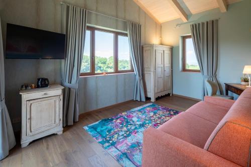 a living room with a couch and a tv at I Quattro Pozzi in La Morra