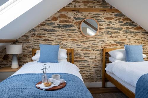 two beds in a attic bedroom with a mirror at The Store in Salcombe