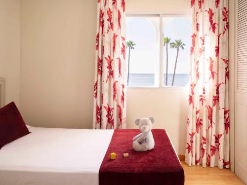 a teddy bear sitting on a bed in a bedroom at Ona Marinas de Nerja Spa Resort in Nerja