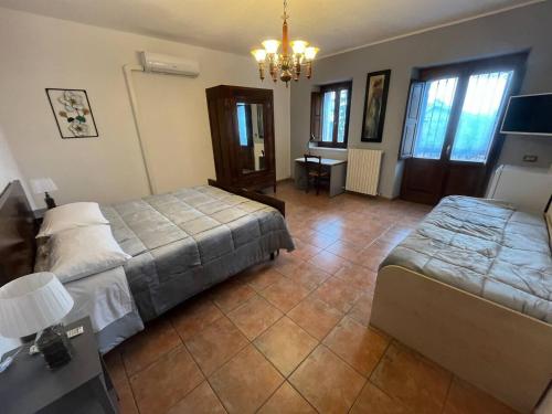 a bedroom with two beds and a chandelier at Villa Maria B&B in Marano Principato