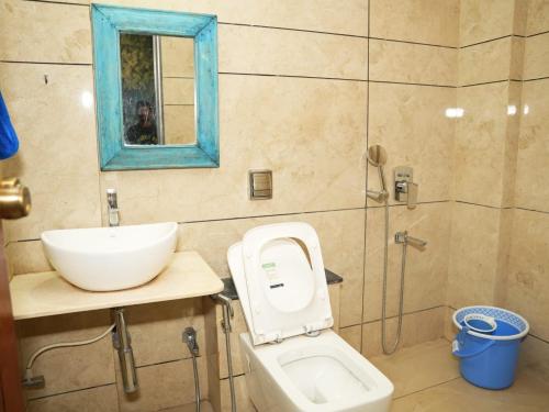 a bathroom with a sink and a toilet and a mirror at The Tree Resort in Malavli