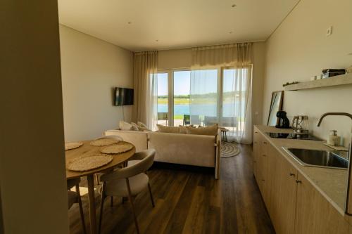 a kitchen and living room with a table and a couch at 313 apartments in Užpelkiai