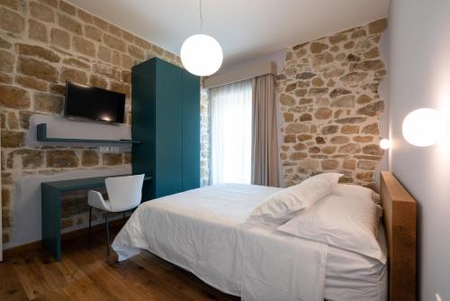 a bedroom with a bed and a stone wall at Agriturismo Fontanavecchia in Torrecuso