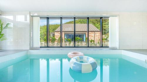 a swimming pool with a view of a house at Danyang Dandelion Pool Villa in Danyang