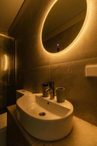 a bathroom with a white sink and a mirror at 313 apartments in Užpelkiai