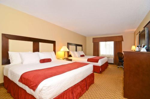a hotel room with two beds and a flat screen tv at Best Western Macomb Inn in Macomb