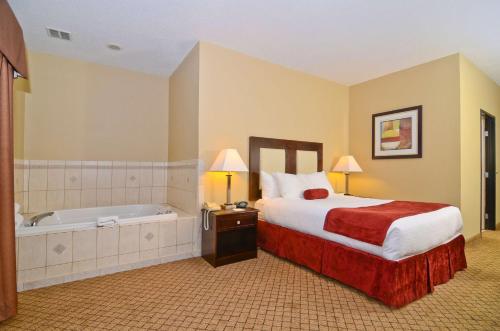 a hotel room with a bed and a bath tub at Best Western Macomb Inn in Macomb