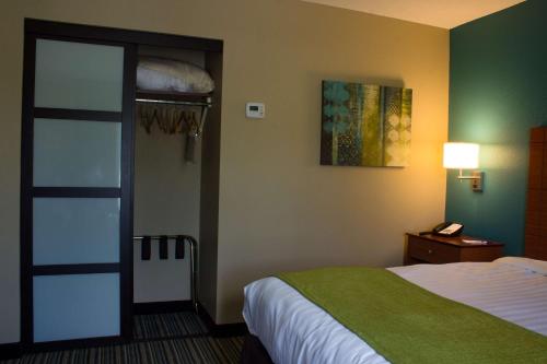 a hotel room with a bed and a phone at BEST WESTERN Plus Menomonie Inn & Suites in Menomonie