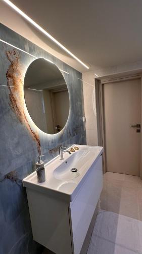 a bathroom with a white sink and a mirror at Sunset Suite Mytikas in Mytikas