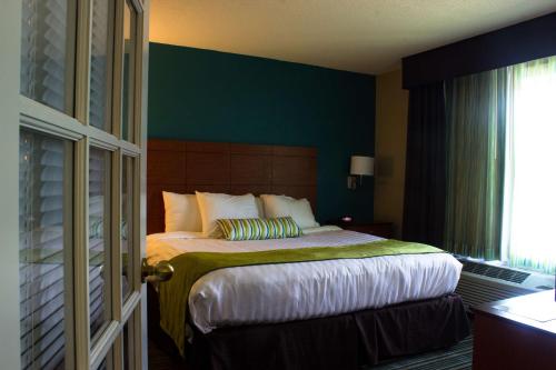 a bedroom with a bed with a green wall at BEST WESTERN Plus Menomonie Inn & Suites in Menomonie