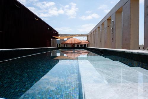 a swimming pool with a umbrella and a building at JOST Hôtel Bordeaux Centre Gare Saint Jean in Bordeaux